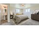 Bright bedroom featuring a queen bed, neutral decor, soft carpet, and an ensuite bathroom at 13805 W 82Nd Ave, Arvada, CO 80005