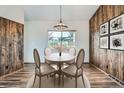Charming dining room with wood paneled accent wall and a light filled window with backyard view at 13805 W 82Nd Ave, Arvada, CO 80005