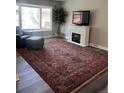 Cozy living room with hardwood floors, a decorative fireplace, and a large bay window that fills the space with natural light at 1477 S Wright Ct, Lakewood, CO 80228