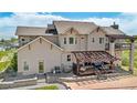 This backyard features a covered pergola, a stone patio, a built-in grill, and ample seating at 7587 Wright Ct, Arvada, CO 80005