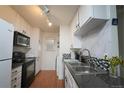 Functional kitchen features white cabinets, contrasting countertops, and modern track lighting at 865 S Quebec St # 302A, Denver, CO 80247