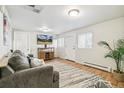 Bright living room with hardwood floors, a comfortable gray sofa, and a decorative rug at 1970 Willow St, Denver, CO 80220