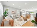 Bright living room featuring hardwood floors, a modern rug, and an open concept to the kitchen at 635 Fillmore St, Denver, CO 80206