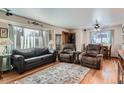 Comfortable living room featuring hardwood floors, a large window, and cozy seating arrangements at 7005 S Ash Cir, Centennial, CO 80122