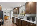 Well-lit kitchen featuring stainless steel appliances, wood-look floors, and ample counter space at 31 W Fremont Ave, Littleton, CO 80120