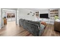 Bright living room featuring hardwood floors, a large gray couch, and built in shelving at 31 W Fremont Ave, Littleton, CO 80120