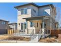 Contemporary home featuring a stone facade, covered porch, and stylish railing at 65 Newport St, Denver, CO 80230
