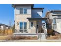 Contemporary home featuring a stone facade, covered porch, and stylish railing at 65 Newport St, Denver, CO 80230