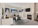 Bright living room features a fireplace, neutral walls, and multiple windows at 71 Woodland Cir, Highlands Ranch, CO 80126
