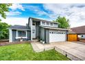 Charming two-story home with a well-manicured lawn, large driveway, and a gray and white facade at 7840 W Portland Ave, Littleton, CO 80128