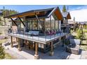 Relax in a modern backyard with an expansive deck, outdoor seating, grill, and a luxurious hot tub at 2250 Highlands Dr, Breckenridge, CO 80424