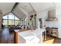 Bright, modern kitchen featuring an island with seating, Wolf range, and vaulted ceilings with grand windows at 2250 Highlands Dr, Breckenridge, CO 80424