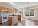 Well-lit kitchen featuring an island, light wood cabinets, and modern appliances at 9960 Kline St, Broomfield, CO 80021