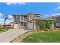 Two-story home with brick and siding and a three-car garage and basketball hoop at 26530 E Euclid Pl, Aurora, CO 80016