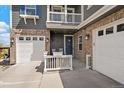 Inviting front porch with seating, leading to a three-car garage of this lovely home at 26530 E Euclid Pl, Aurora, CO 80016