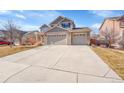 Exterior showcasing the large concrete driveway and three-car garage of this two story house at 13457 Locust St, Thornton, CO 80602