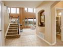 Bright entryway featuring tile flooring, a staircase, and large windows for natural light at 10253 Fairgate Way, Highlands Ranch, CO 80126