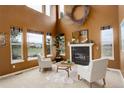 Two-story living room featuring a fireplace and large windows for natural light at 10253 Fairgate Way, Highlands Ranch, CO 80126