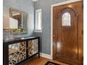 Inviting foyer features a wood door with glass inset, decorative mirrored console table, and beautiful hardwood floors at 2215 E 7Th Avenue Pkwy, Denver, CO 80206