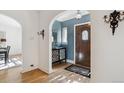 Inviting foyer showcasing a wood door with glass inset, decorative console table, and beautiful hardwood floors at 2215 E 7Th Avenue Pkwy, Denver, CO 80206