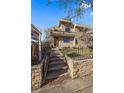 Beautiful home with a stone and stucco facade, inviting entryway, and a balcony, complemented by professional landscaping at 3323 W Hayward Pl, Denver, CO 80211