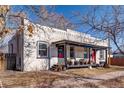 View of the house with bright red front doors, covered porch and landscaping with leafless tree branches at 723 W 5Th Ave, Denver, CO 80204