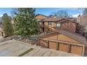 A two-story townhouse featuring a three-car garage, wood siding, balcony, and well-maintained landscaping at 9411 W 89Th Cir, Westminster, CO 80021