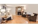 Inviting living room with a stone fireplace, hardwood floors, and comfortable seating, perfect for relaxation and gathering at 9411 W 89Th Cir, Westminster, CO 80021