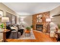 Cozy living room featuring a stone fireplace, hardwood floors, and ample natural light from a large window at 9411 W 89Th Cir, Westminster, CO 80021