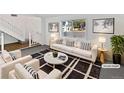 This staged living room features a cozy layout, bright natural light, and modern furnishings at 3661 S Joplin St, Aurora, CO 80013