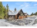 Attractive exterior showcasing stonework, wood siding, and three garage doors, blending mountain charm at 50 Cooney Ct, Breckenridge, CO 80424