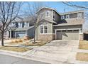 Charming two-story home with stone accents, two-car garage, and concrete driveway at 10251 Rifle St, Commerce City, CO 80022