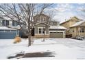 Two-story house with a snow-covered front yard and attached garage at 10251 Rifle St, Commerce City, CO 80022