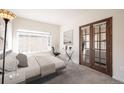 Cozy bedroom featuring a large window and stylish french doors leading to the living room at 9973 E Carolina Cir # 104, Aurora, CO 80247