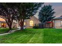 Landscaped front yard featuring lush green grass, mature trees, and a charming brick home at 2745 N Saint Paul St, Denver, CO 80205
