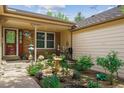 Charming garden space at the front entrance features brick accents and a covered porch at 6143 E Hinsdale Ave, Centennial, CO 80112