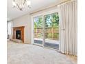 Inviting living room with a brick fireplace and sliding glass doors leading to the outdoor deck at 6143 E Hinsdale Ave, Centennial, CO 80112