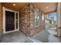 Inviting front porch with stone accents, providing a cozy entry to the home and an outdoor sitting area at 22870 E Chenango Ave, Aurora, CO 80015