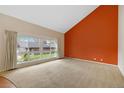 Spacious living room with a large window offers lots of natural light, and a orange accent wall at 6495 E Happy Canyon Rd # 171, Denver, CO 80237