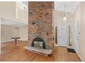 A spacious room features a large brick fireplace, a pendant light and hardwood floors at 6495 E Happy Canyon Rd # 171, Denver, CO 80237