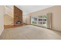 Bright living room features a large picture window, brick fireplace and a staircase leading to a second level at 6495 E Happy Canyon Rd # 171, Denver, CO 80237