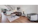 Modern living room with sleek furniture, hardwood floors, and a staircase at 714 Sedge Way, Lafayette, CO 80026