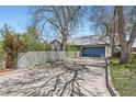 Spacious driveway leading to the home, featuring a two-car garage and partial fencing at 2022 S Clay St, Denver, CO 80219