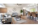 Open concept living room with hardwood floors and a view into an updated kitchen at 9021 Raleigh St, Westminster, CO 80031