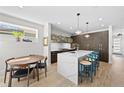 Bright kitchen with marble countertop island, stylish stools, modern lighting, and hardwood floors at 4426 Utica St, Denver, CO 80212