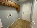Laundry room with tile flooring, wooden cabinets, and modern hookups at 20148 E Dartmouth Dr, Aurora, CO 80013