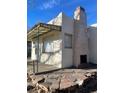 Home exterior featuring rock chimney, metal awning, stucco walls, and unique stonework at 4445 E Florida Ave, Denver, CO 80222