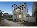 Charming three-story home with a manicured lawn, modern architectural details, and a welcoming entrance at 18211 E 51St Ave, Denver, CO 80249