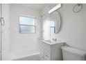 Clean bathroom featuring white tile, a modern vanity, and a well-lit mirror at 3299 S Forest St, Denver, CO 80222