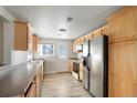 Bright kitchen featuring stainless steel appliances, wood cabinets, and light wood flooring at 3299 S Forest St, Denver, CO 80222